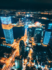 Aerial night view of Ho Chi Minh City skyline with glowing skyscrapers and neon lights, Drone panorama of Saigon downtown, illuminated towers and busy streets of vibrant city