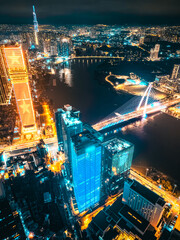 Aerial night view of Ho Chi Minh City skyline with glowing skyscrapers and neon lights, Drone panorama of Saigon downtown, illuminated towers and busy streets of vibrant city