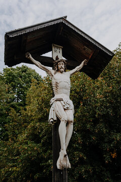 Traditional Alpine Wayside Cross with Jesus Christ Statue &ndash; Religious Wooden Crucifix on Mount Calvary in Castelrotto, South Tyrol