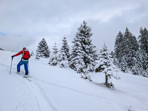 A ski tourer in a snowy winter landscape in the Chiemgau Alps. This sport involves traveling through deep snow away from groomed slopes