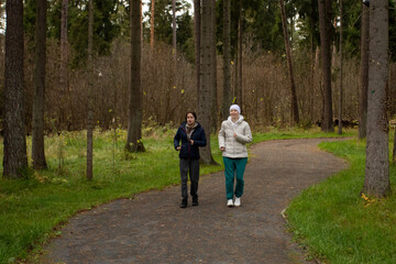 Obraz premium Two women jogging on nature trail, concept of emotional support, self-care, and cancer awareness.