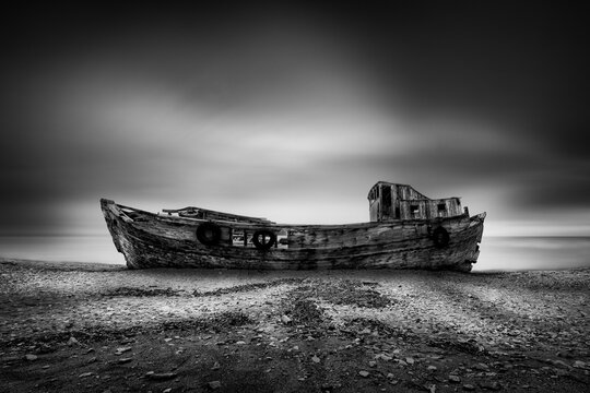 Wrecks 010 - Boat wreck at Agalipa, Skyros. Abandoned fishing boat on the beach against a cloudy sky