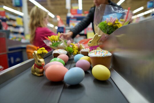 Spring celebration at a store with flowers, Easter eggs, and baked goods on the checkout counter