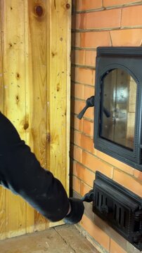 A stove master checks the operation of the firebox door and ash door in a newly built stove. Opens and closes the doors. Construction of a heating stove. Vertical video.