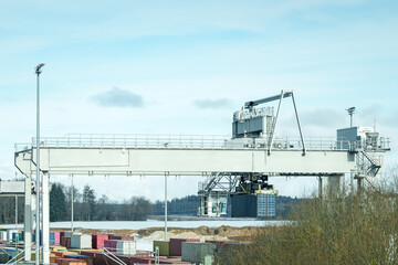 Obraz premium Container handling equipment at a busy shipping yard during daytime near a port area