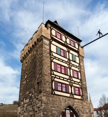 Historic Schelztorturm tower with half-timbered facade and tightrope walker figure in Esslingen