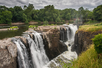 Fototapeta premium A large waterfall pours over a rocky gorge in Paterson, New Jersey