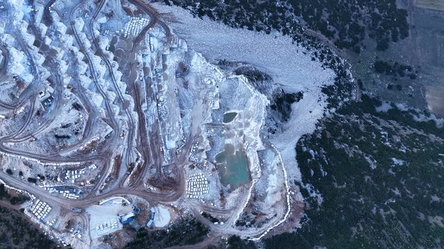 Aerial view of the massive marble quarry in Burdur, Turkey. Drone footage of the terraced structure in the industrial mining area.