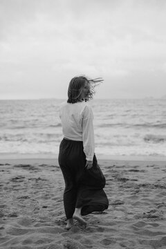 Nha Trang, Vietnam-March 1,2025: young woman in clare clothes laughs walking at empty beach Nha Trang, Vietnam. Black - white foto