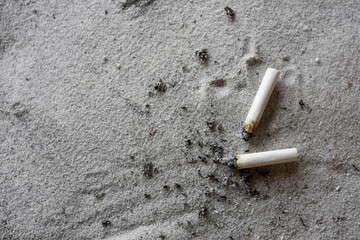 Cigarette Butts and Ash on Sand Health Risk and Environmental Pollution Concept