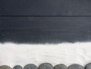Black Wooden Background with White Sand and Zen Stones Minimal Spa Concept Copy Space