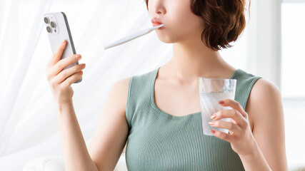 スマートフォンを見ながら歯磨きをする女性・美容イメージ, Woman brushing teeth while looking at smartphone, beauty concept © Trickster*