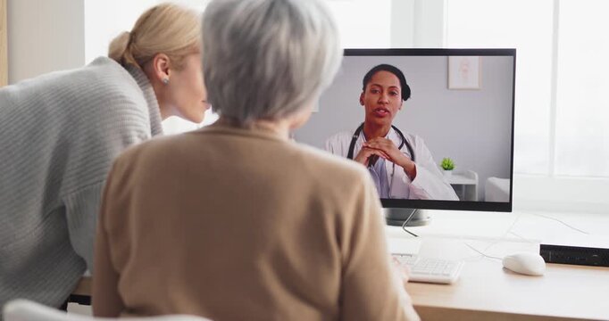 Senior and daughter join online doctor video call. At home they sit at a computer screen as the doctor explains care during telehealth consultation. Clear telehealth family care concept.