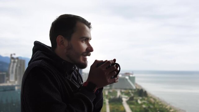 photographer holding camera on Batumi balcony, freelance creative scouting composition for sunrise over Black Sea, curved coastline and modern towers in background, denim jacket, focused expression,
