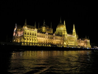 Obraz premium The Hungarian Parliament at night with dark sky and reflection in Danube river. It was designed in Neo-Gothic style, although it also bears Renaissance and Baroque stylistic flourishes.