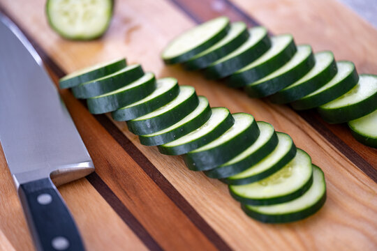 Sliced Cucumber with Chef Knife on Wooden Cutting Board