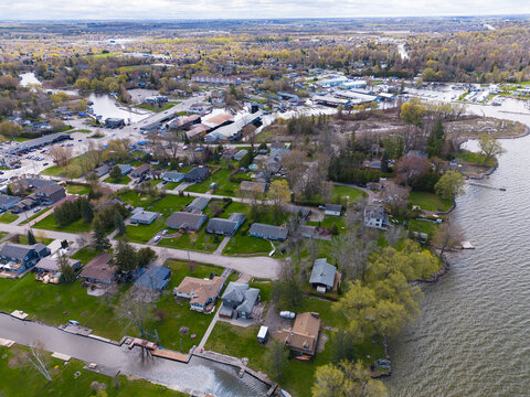 Aerial view of georgina shoreline on lake simcoe showing waterfront homes, marinas and tree lined streets, a suburban lakeside community blending nature and residential life