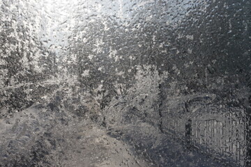 A window with frost on it and a blurry background