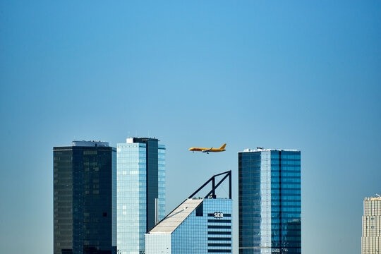 TALLINN, ESTONIA - May 10, 2018: A DHL cargo plane flying past modern skyscrapers in Tallinn.