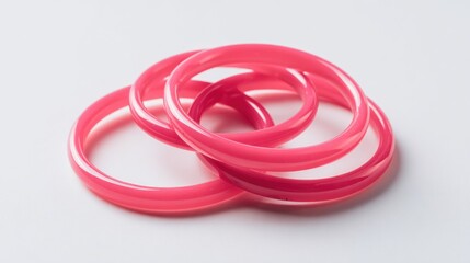 Naklejka premium Three pink plastic bangles, layered on a white surface