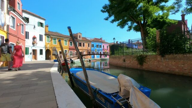 A view along Fondamenta di Terranova footpath in Burano, Venice, Italy. Colorful houses, Terranova bridge and boats moored in the waterway, Burano, Venice, Italy.