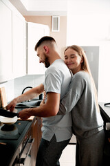 Obraz premium Couple cooking breakfast together in kitchen, morning lifestyle