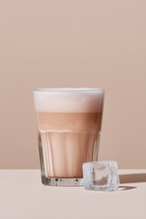 A tall glass holds a refreshing pink drink with a frothy, creamy top