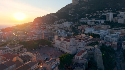 Fototapeta premium Aerial Cityscape Golden Hour Over Facades, Hillside Skyline And Coastal Bay Drone Sweeps Across Ornate Palace. Monaco