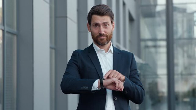 Professional Caucasian business man look on wristwatch waiting for meeting showing late looking at camera mature businessman middle-aged male checking time pointing on watch entrepreneur in city