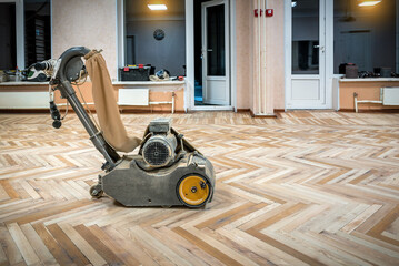 Professional sanding, polishing, grinding machine during wooden floor renovation