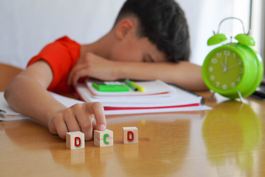 child with DCD frustrated doing homework, importance of educational needs and special attention to this disorder.