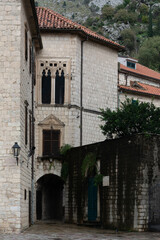 Fototapeta premium Narrow stone street with historic Mediterranean buildings and ornate gothic window details.