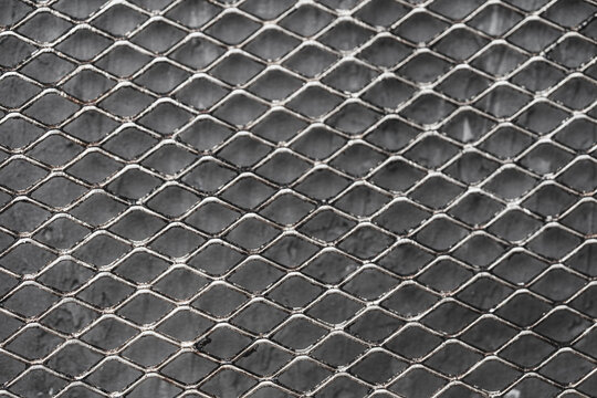 Metal mesh on a gray background. Close-up, top view. Background.