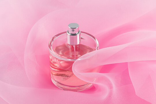 Elegant perfume bottle on pink organza fabric
