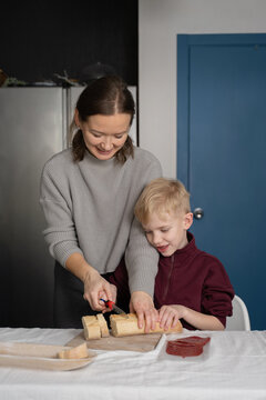 Mother and child preparing bread in kitchen