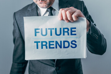 Businessman holding paper with Future trend text printed, symbolizing forecasting, innovation, market direction, and strategic business planning.