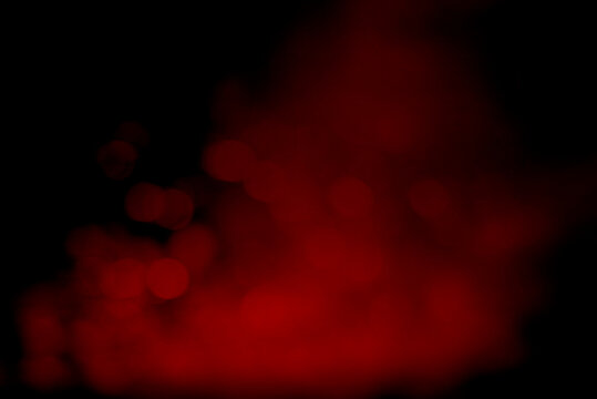 Dramatic red smoky bokeh lights against deep black background