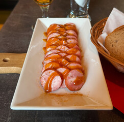 Sliced ​​fried sausage with wooden forks. Close-up