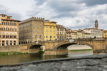 Fototapeta premium Famous historic Ponte Vecchio bridge and old buildings along the Arno river in Florence Italy