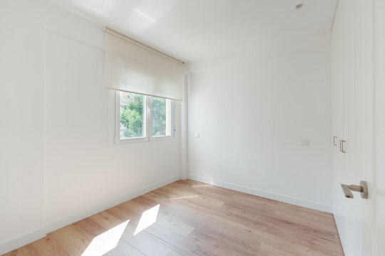 Empty bedroom with window and built-in closet