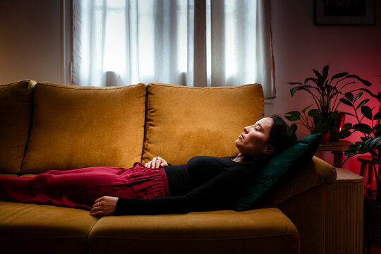 Relaxed woman peacefully sleeping on couch