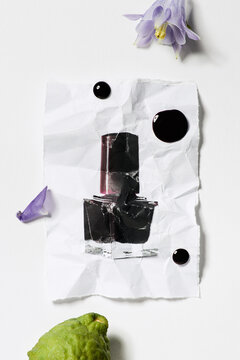 Creative still life with burgundy nail polish and floral accents
