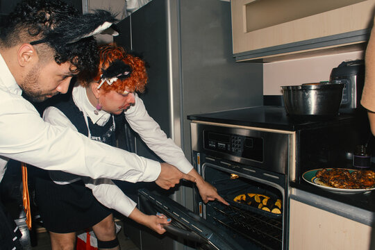 Friends cooking together in a kitchen, enjoying a fun moment