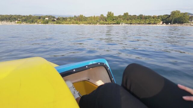 Person pedaling a boat on Lake Leman during summer
