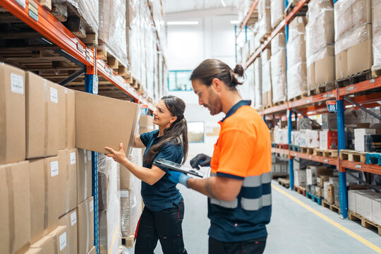 Logistic workers managing inventory and picking orders in warehouse