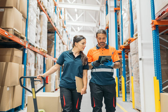 Logistic workers using digital tablet and manual pallet jack