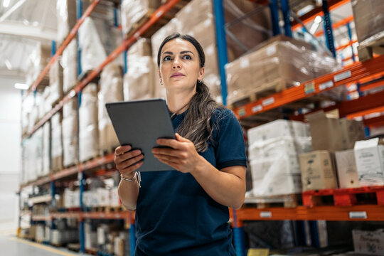 Logistic worker using digital tablet checking inventory in warehouse