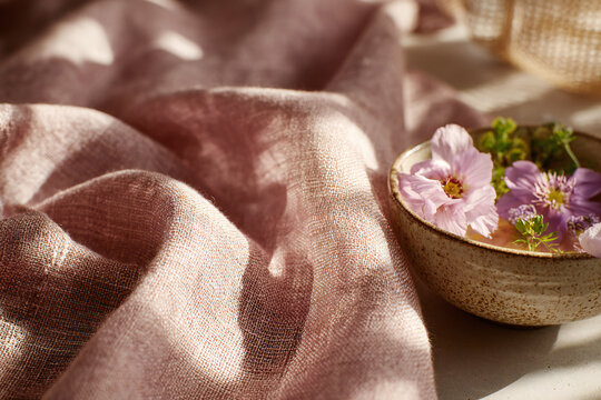 Sage green linen tablecloth with Sevilla gazpacho and edible flowers, macro food photography