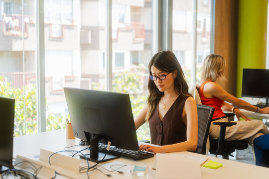 Woman at her desk, engrossed in computer work