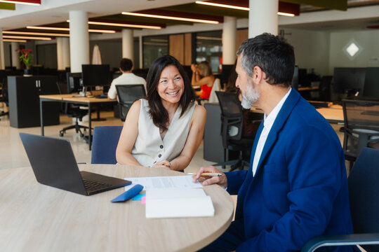 Man and woman discuss business at a desk